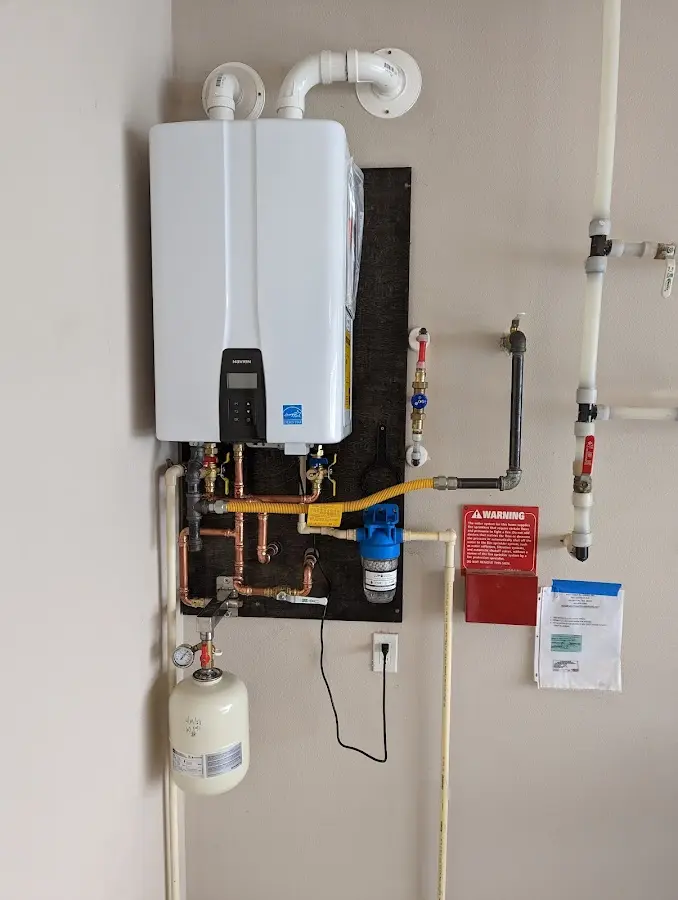 Professional plumber installing copper piping in a De Queen home